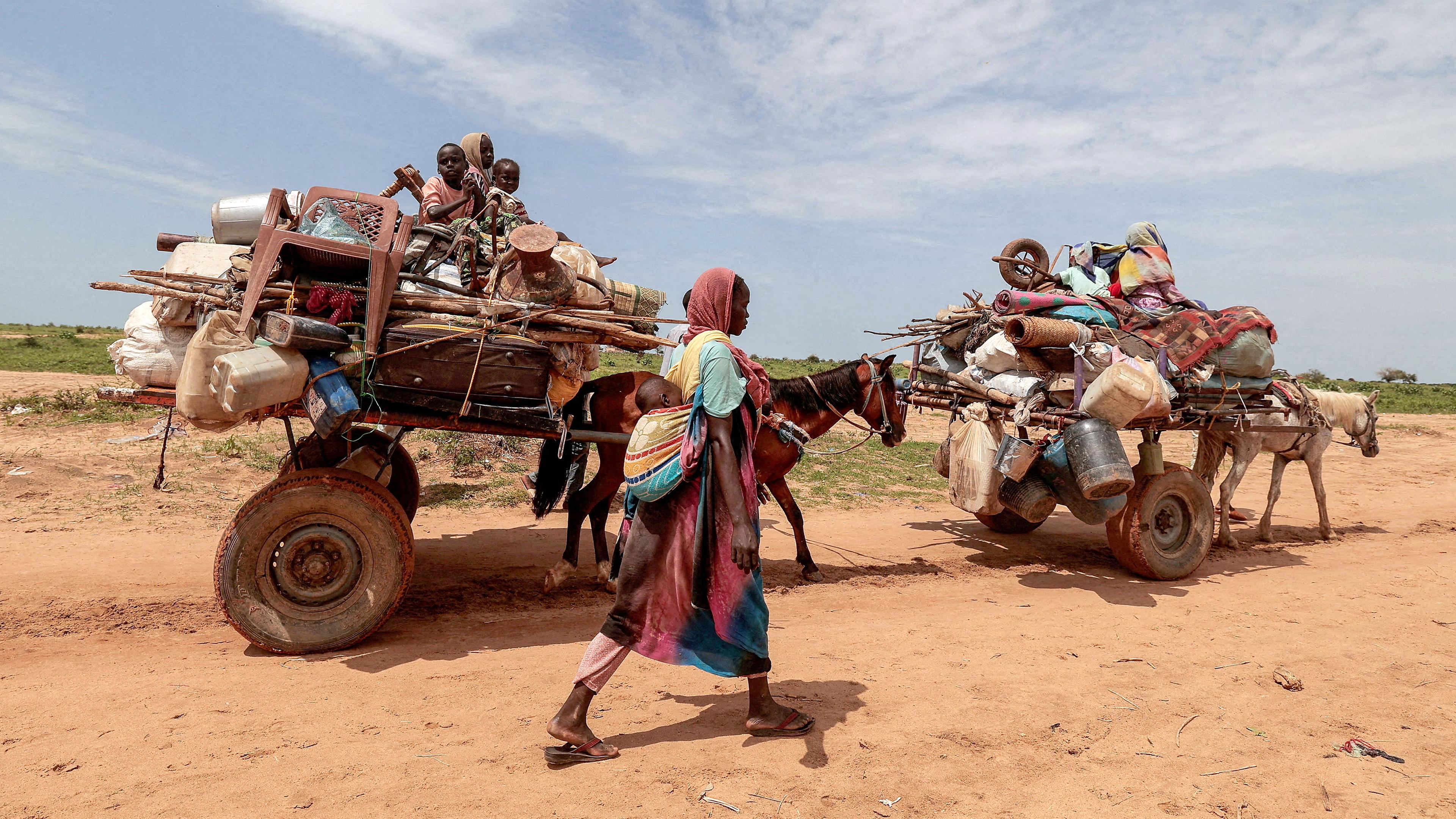 Eine sudanesische Frau, die vor dem Konflikt in Murnei in der sudanesischen Region Darfur geflohen ist, überquert die Grenze zwischen dem Sudan und dem Tschad in Adre