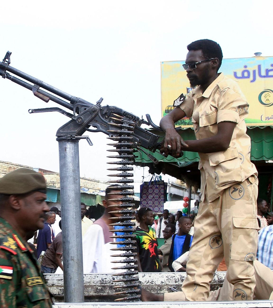 Es sind Soldaten der Miliz in Sudan zu sehen. Einer der Männer stützt sich an einem Standgeschützt ab.