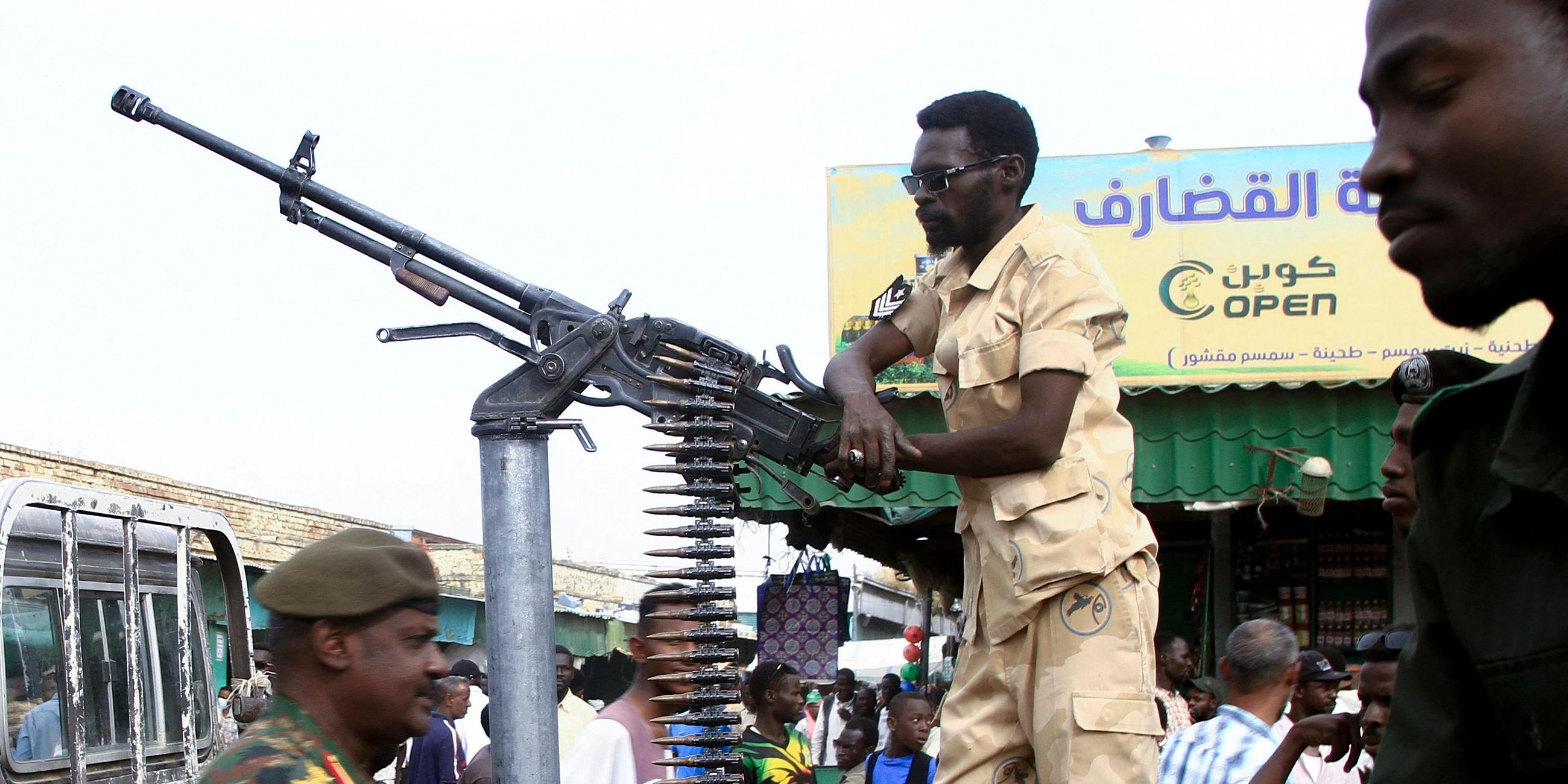 Es sind Soldaten der Miliz in Sudan zu sehen. Einer der Männer stützt sich an einem Standgeschützt ab.