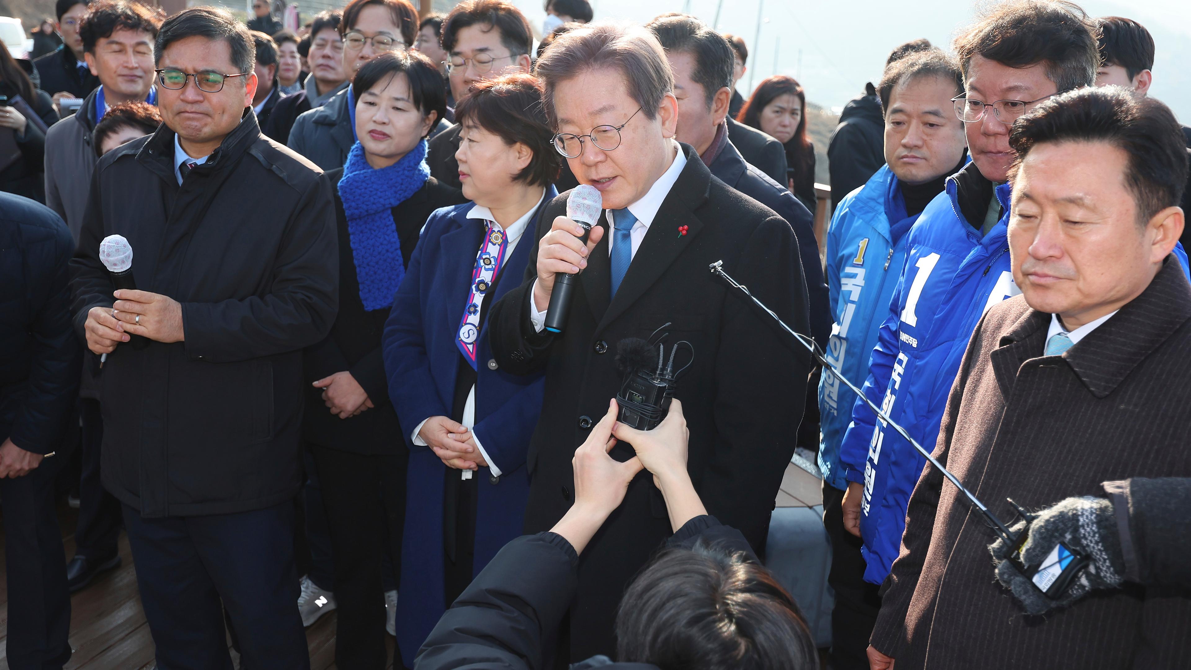 Südkorea, Busan: Südkoreas Oppositionschef Lee Jae Myung (M), südkoreanischer Oppositionsführer, spricht, während er die Baustelle eines neuen Flughafens besucht.
