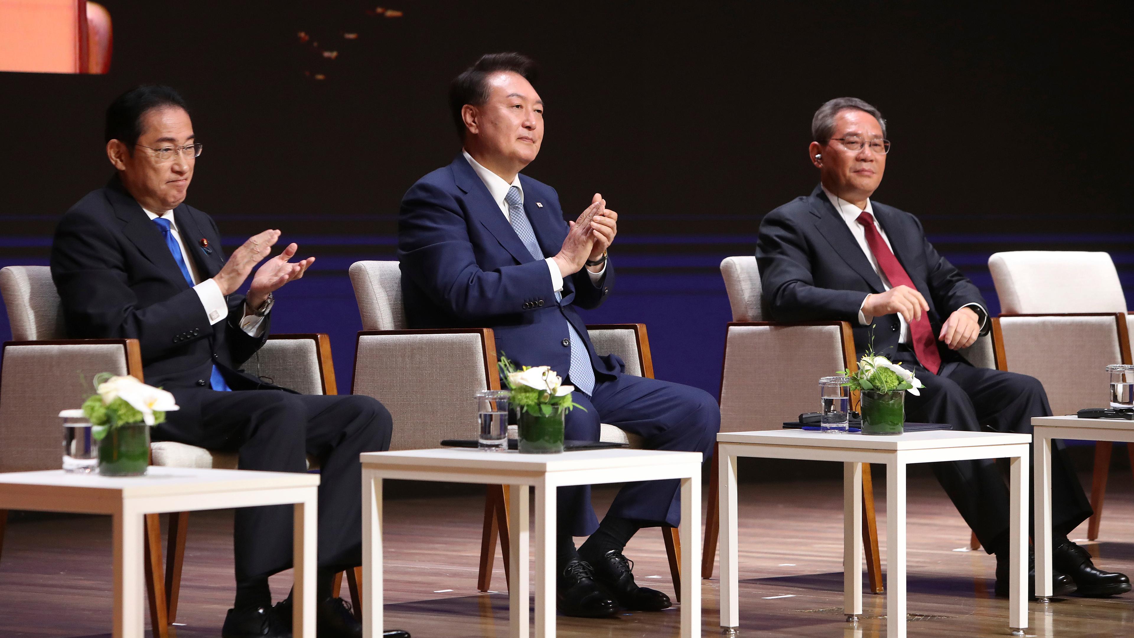 Südkorea, Seoul: Der japanische Ministerpräsident Fumio Kishida (l-r), der südkoreanische Präsident Yoon Suk Yeol und der chinesische Ministerpräsident Li Qiang nehmen am Wirtschaftsgipfel in der koreanischen Industrie- und Handelskammer teil.