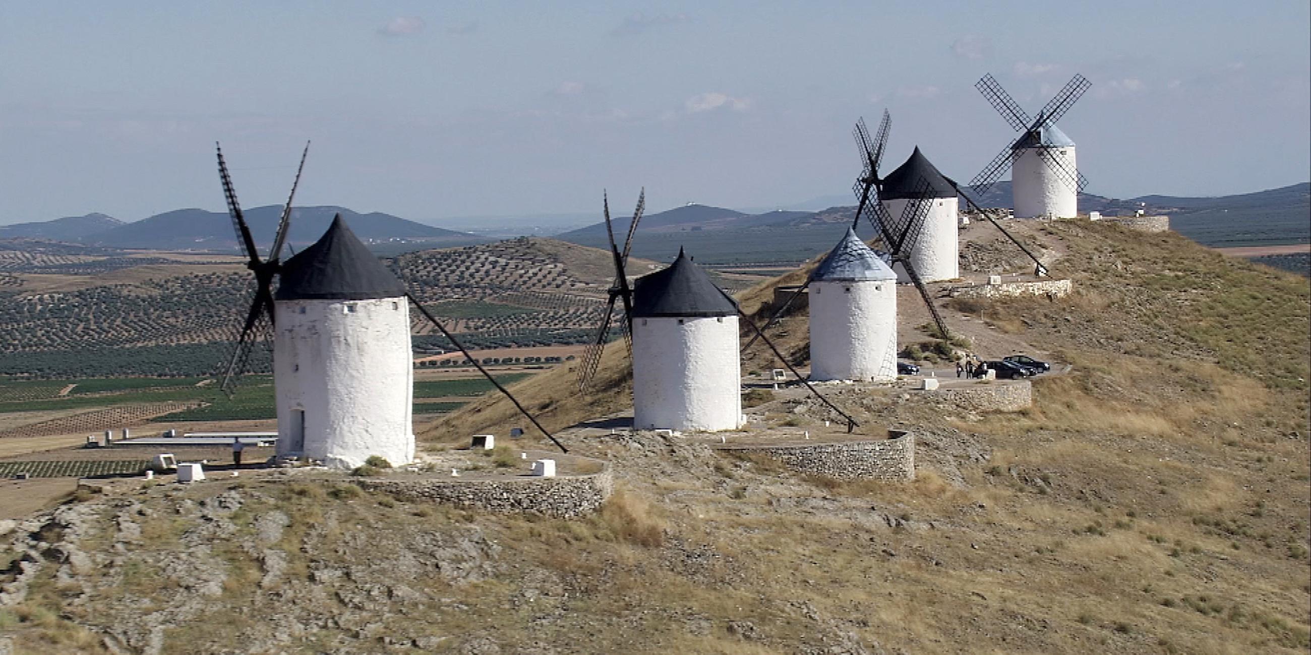 Fünf weiße Windmühlen auf einem Hügelrücken.