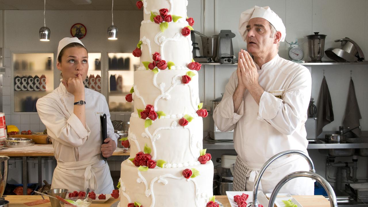 "Inga Lindström: Süße Leidenschaft": Hilla (Josephin Busch) und der berühmte Patissier Mika Stendal (Heinrich Schafmeister) garnieren eine Hochzeitstorte in der Hotel-Küche.