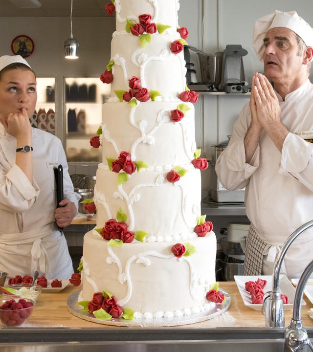 "Inga Lindström: Süße Leidenschaft": Hilla (Josephin Busch) und der berühmte Patissier Mika Stendal (Heinrich Schafmeister) garnieren eine Hochzeitstorte in der Hotel-Küche.