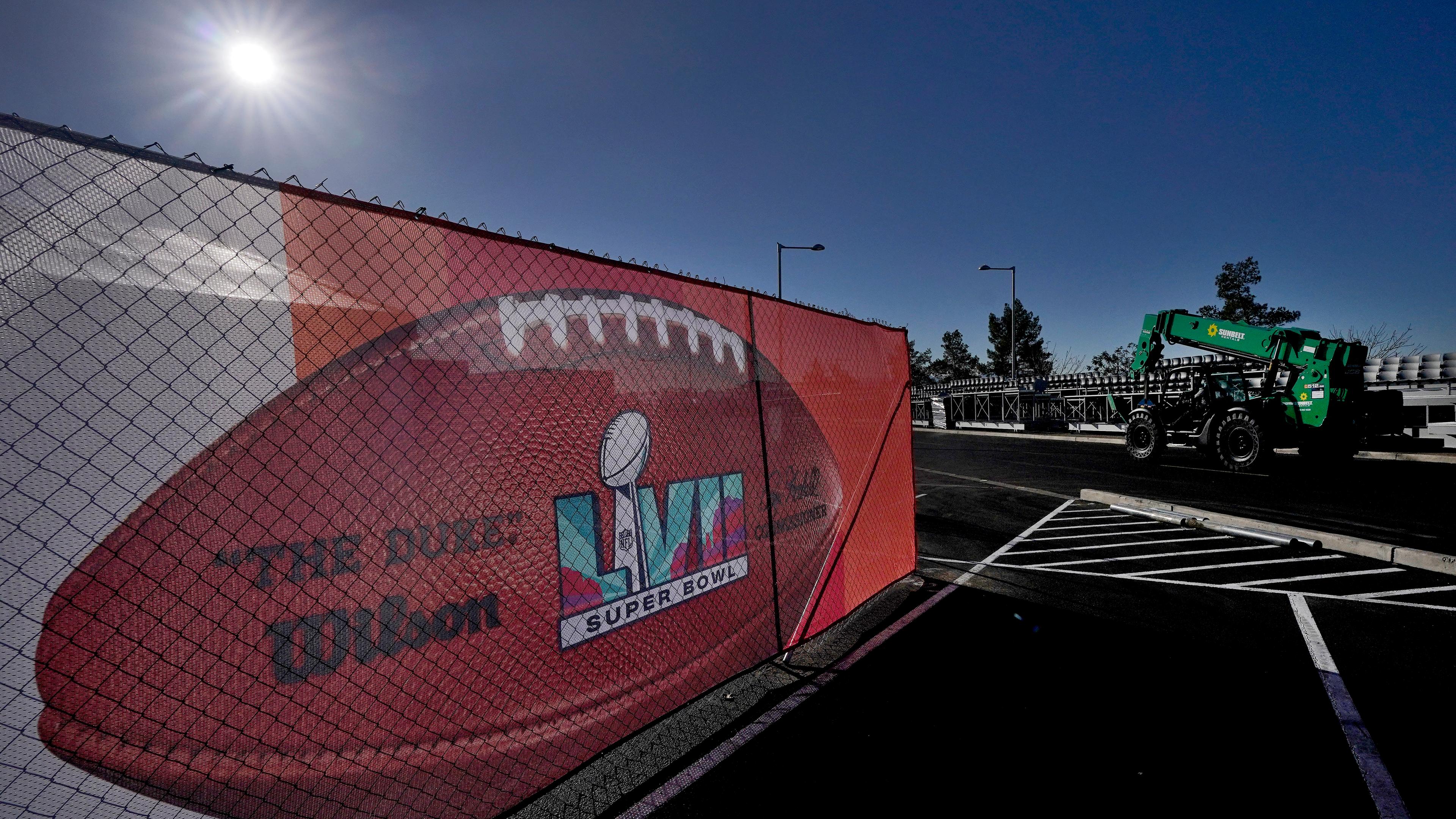 Ein Banner mit dem Super-Bowl-Logo hängt am Bauzaun. Die Sonne scheint.