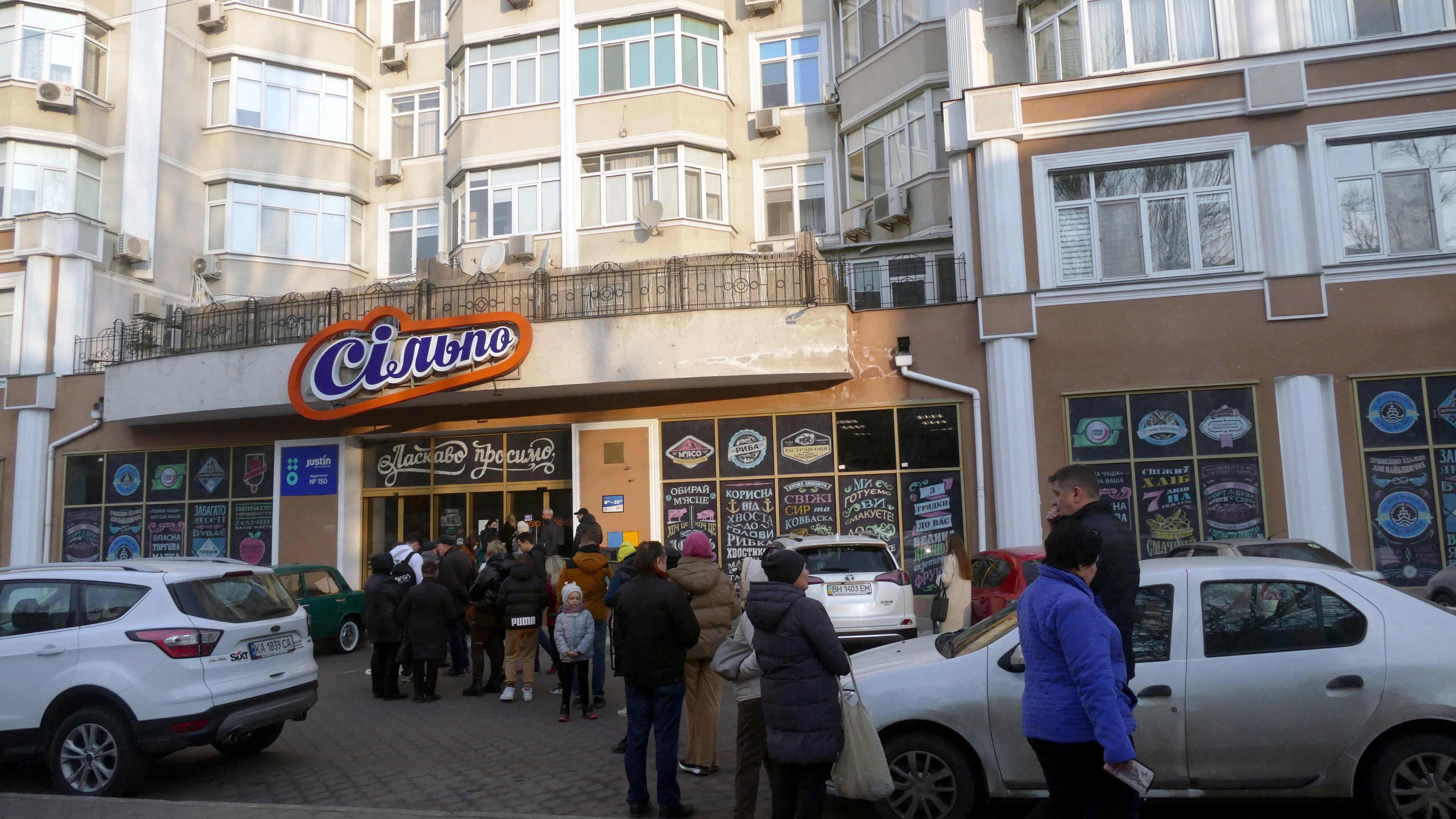 Menschen stehen in einer Schlange vor einem Supermarkt im Süden der Ukraine.