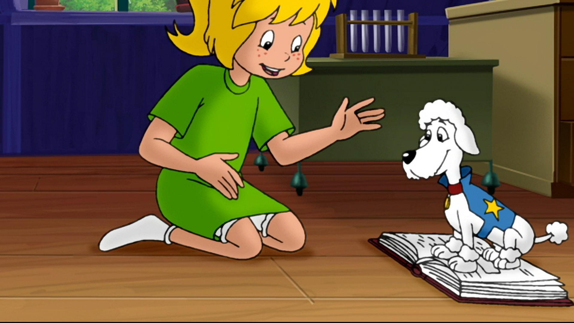 Superpudel Puck sitzt auf Bibis Mathebuch. Bibi sitzt ihm gegenüber.