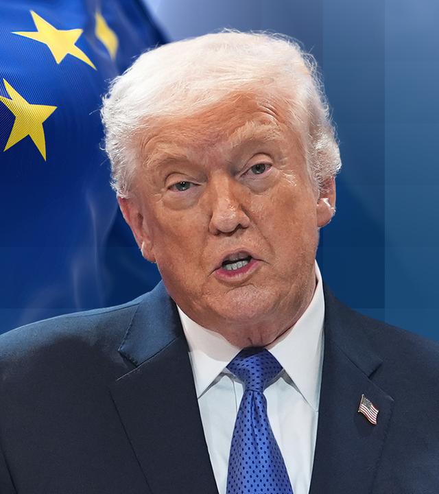 Der US-Präsident Trump redet und hat daher den Mund offen. Im Hintergund ist die Flagge der Europäischen Union.