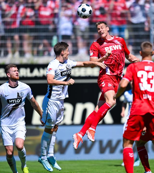  Steffen Tigges von Köln (oben, r) und Carlo Sickinger von Elversberg im Kopfballduell. 