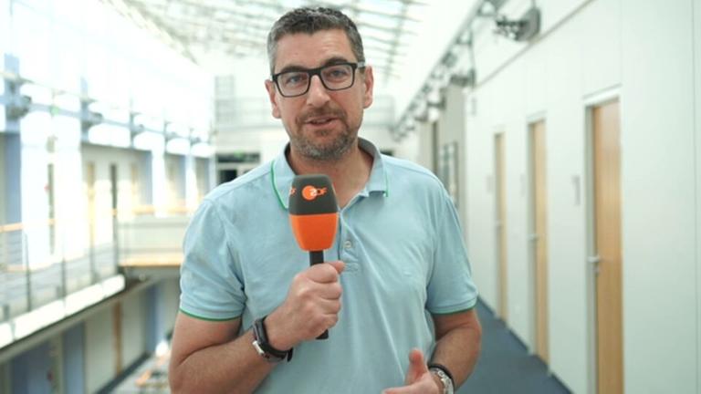 ZDF-Reporter Sven-Hendrik Hahn mit Mikrofon in der Hand.