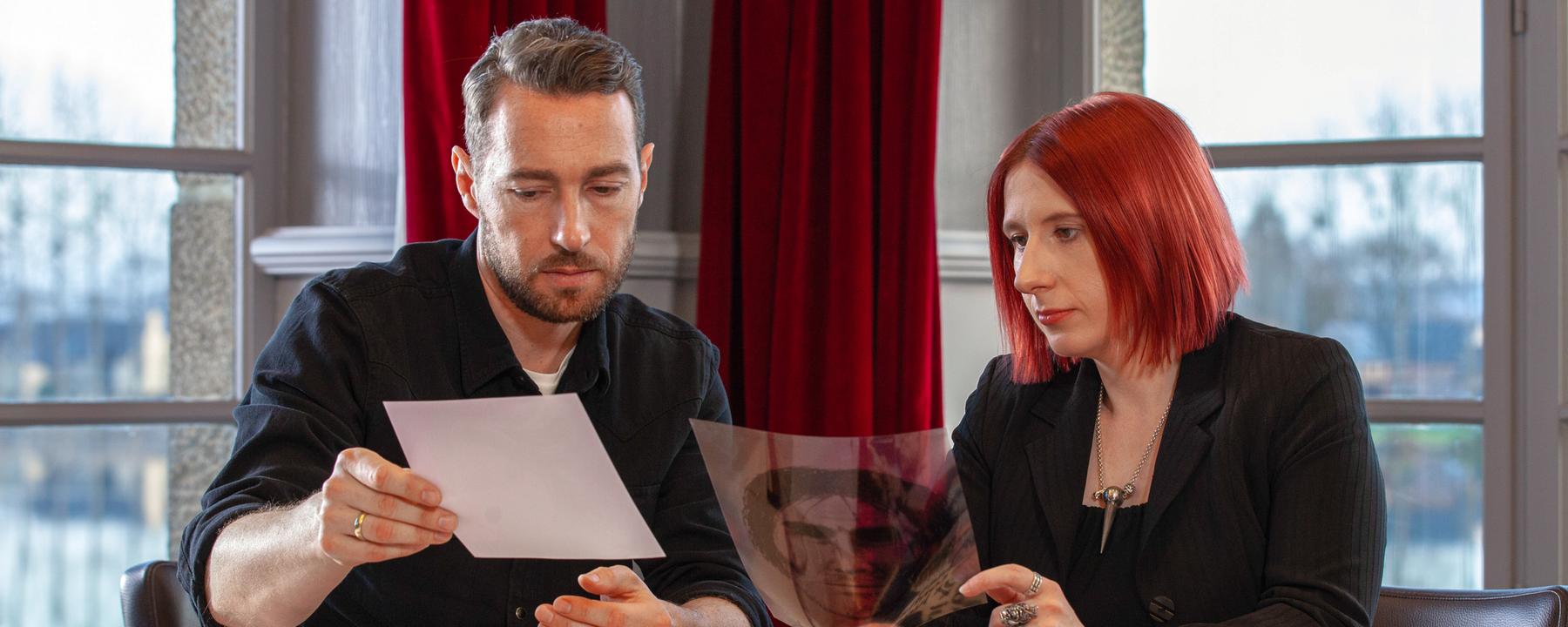 "Tod in der Bretagne": Voss und Benecke an einem Tisch sitzend mit Unterlagen zum Fall in der Hand.