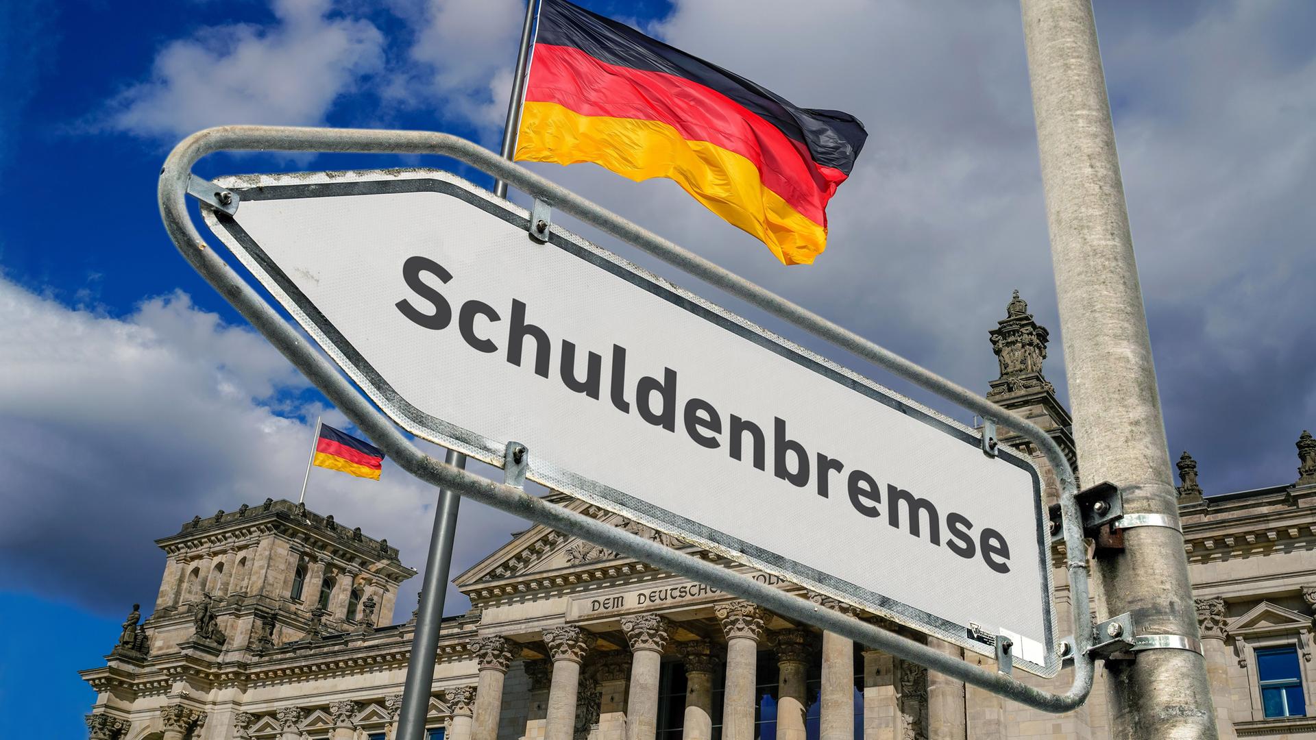 Hinter einem Straßenschild mit der Aufschrift Schuldenbremse ist der Bundestag mit wehender Deutschlandflagge zu sehen.