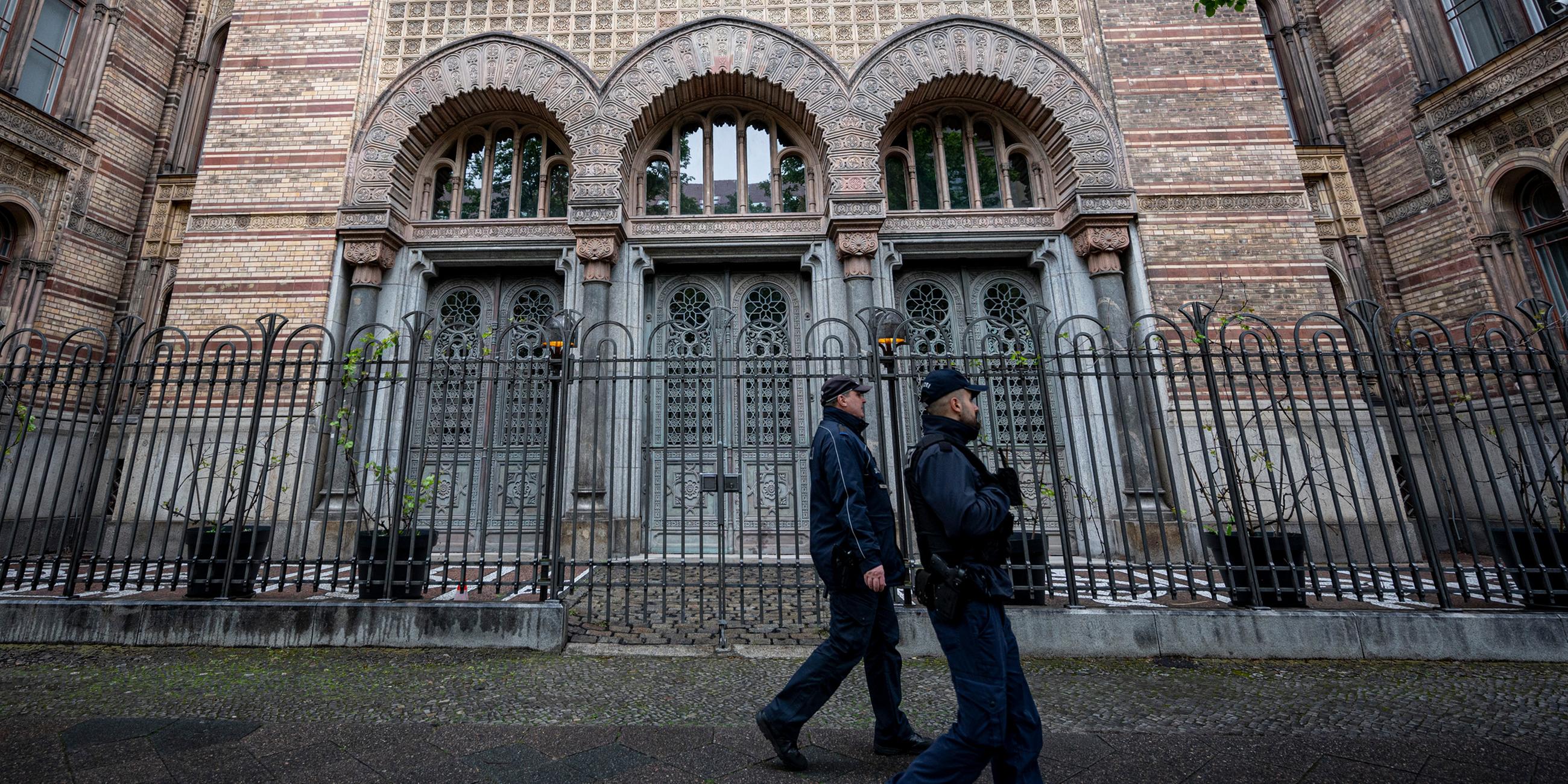 Zwei Polizisten laufen vor dem Eingang der Neuen Synagoge Berlin am 14.05.201 vorbei.