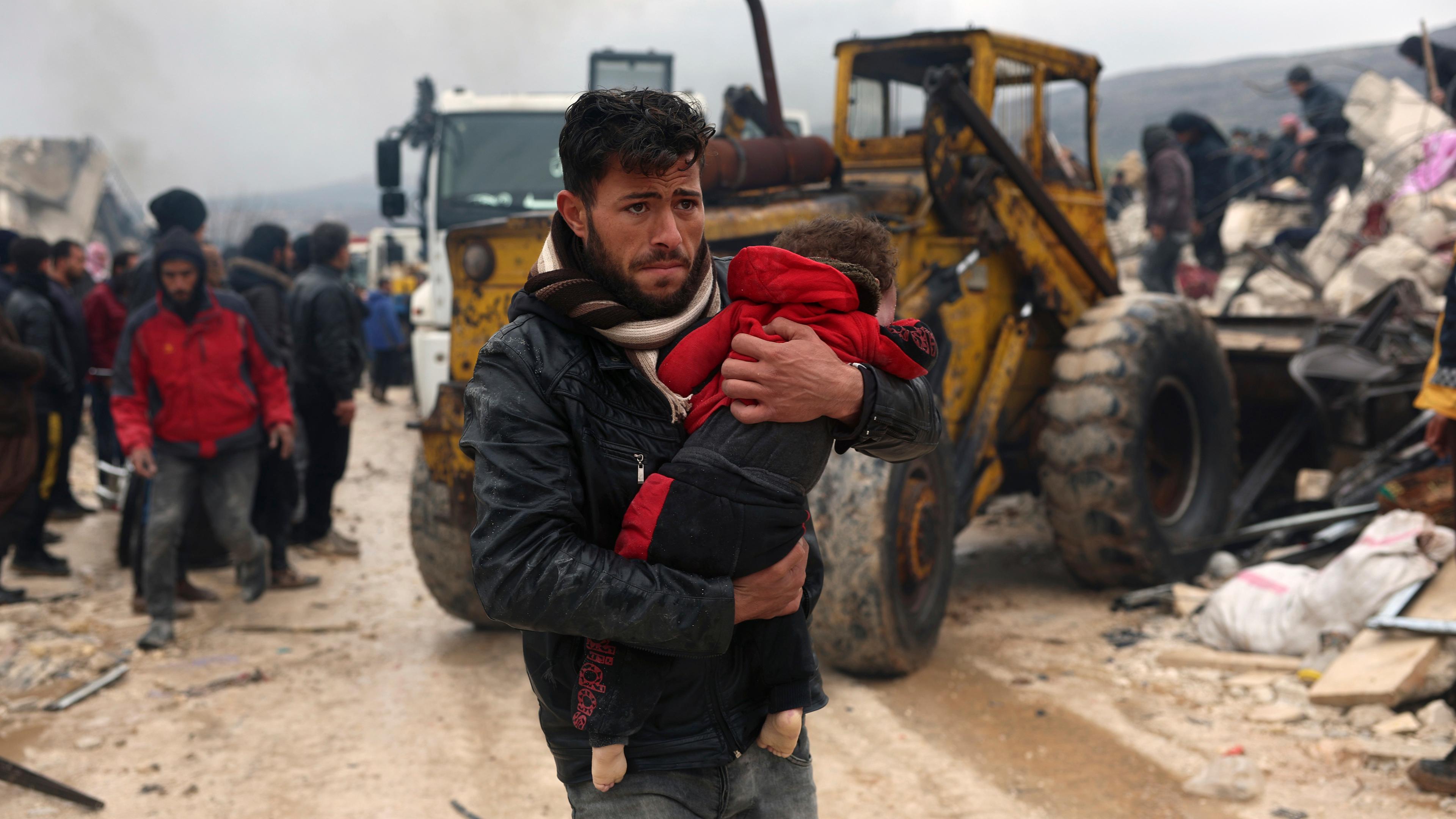 Syrien, Besnia: Ein Mann hält ein Kind im Arm.