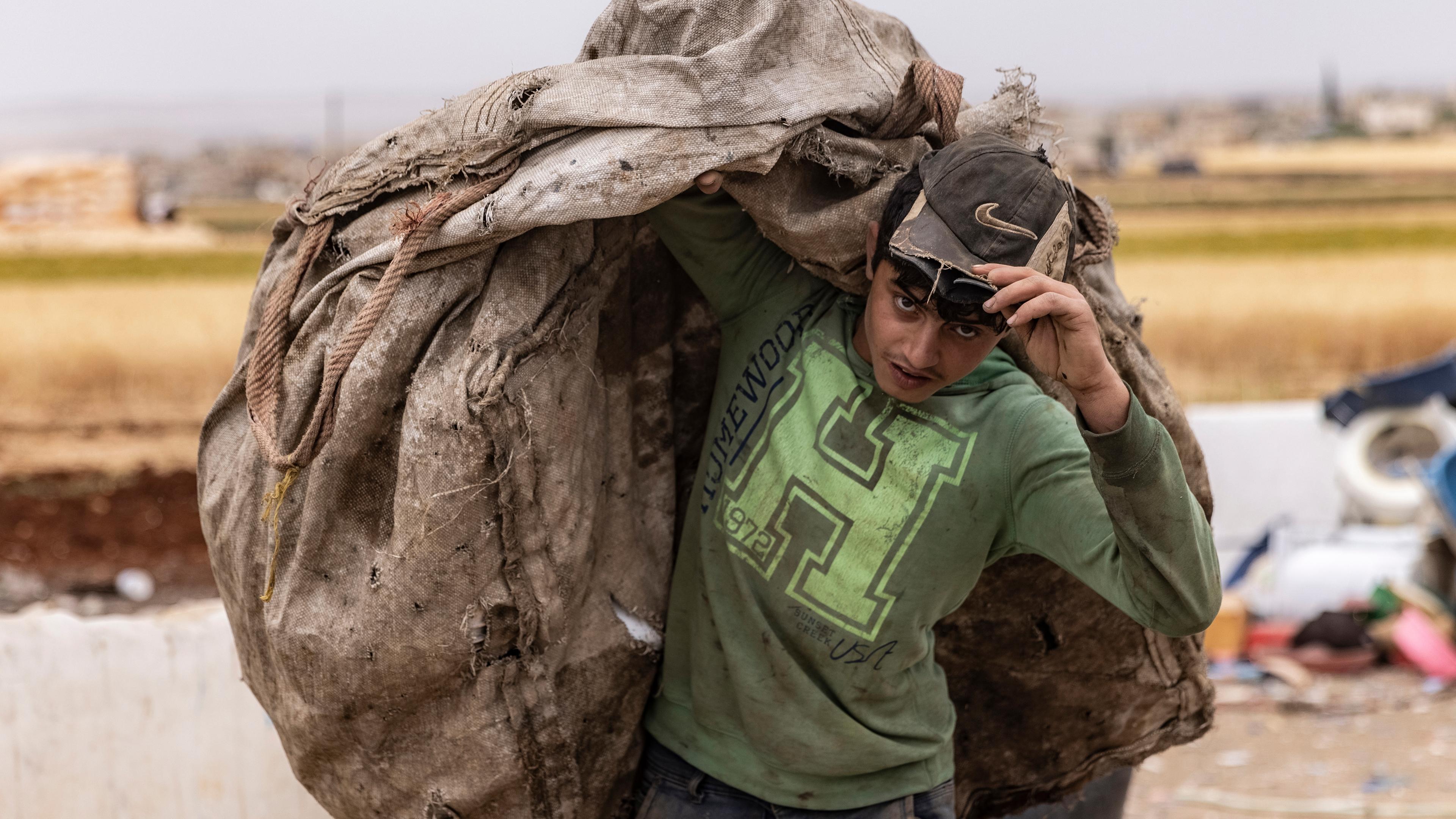 Syrien, Idlib: Ein Arbeiter bringt die auf Mülldeponien gesammelten Kunststoffteile zu einer Zerkleinerungsmaschine.