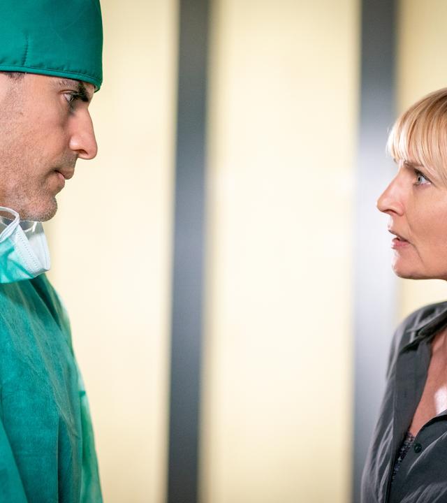 Dr. Sharif (Atheer Adel) und Melanie (Sanna Englund) stehen sich im Flur des EKH gegenüber. Melanie schaut Dr. Sharif entsetzt an. Er sieht sie traurig an.