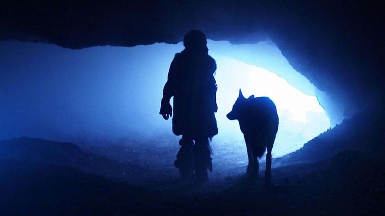 Szenenfoto: Mensch und Hund in der Höhle von Chauvet