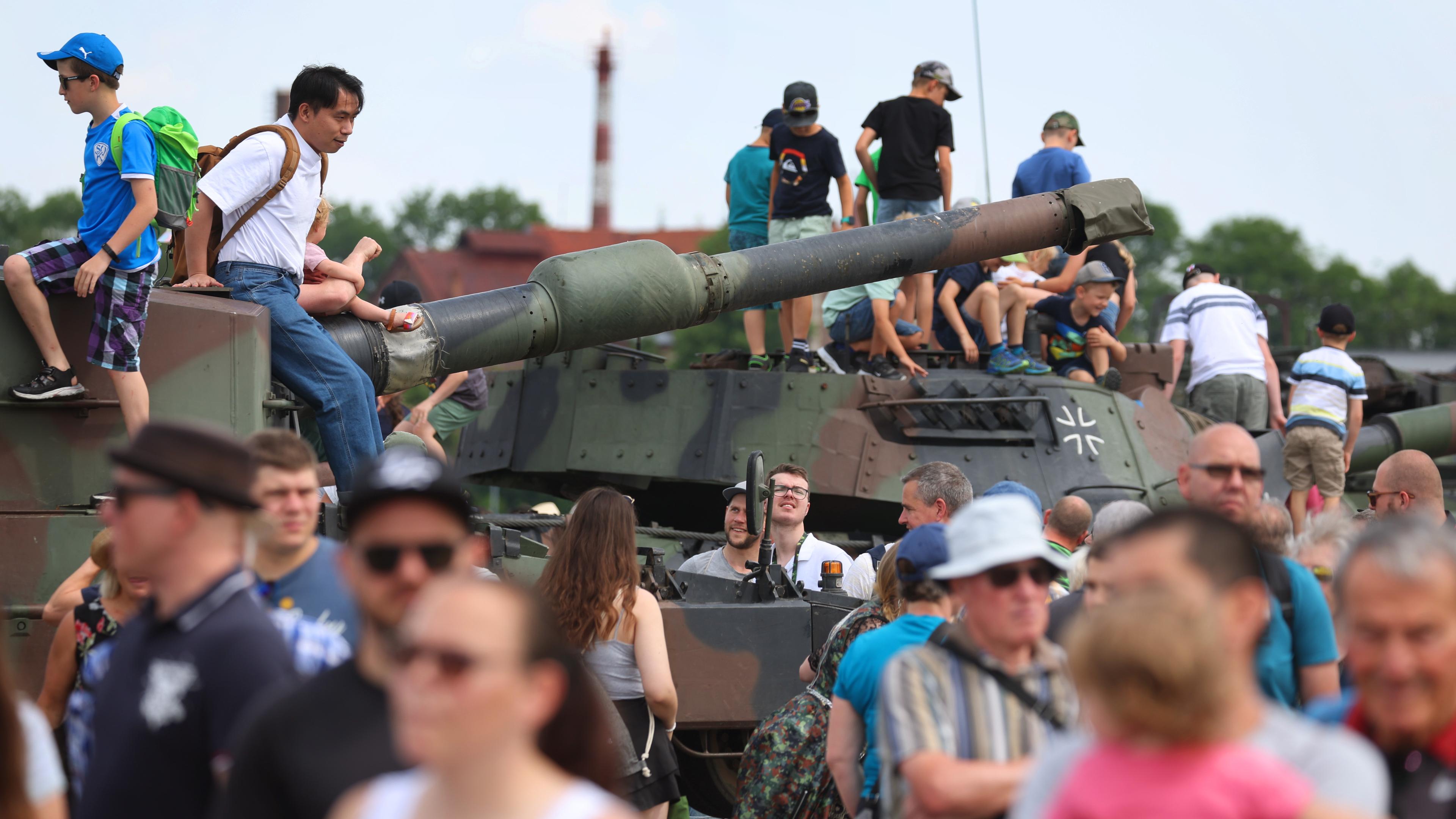 Bayern, Kaufbeuren: Besucher des Tages der Bundeswehr lassen sich auf dem Fliegerhorst auf Panzern fotografieren.