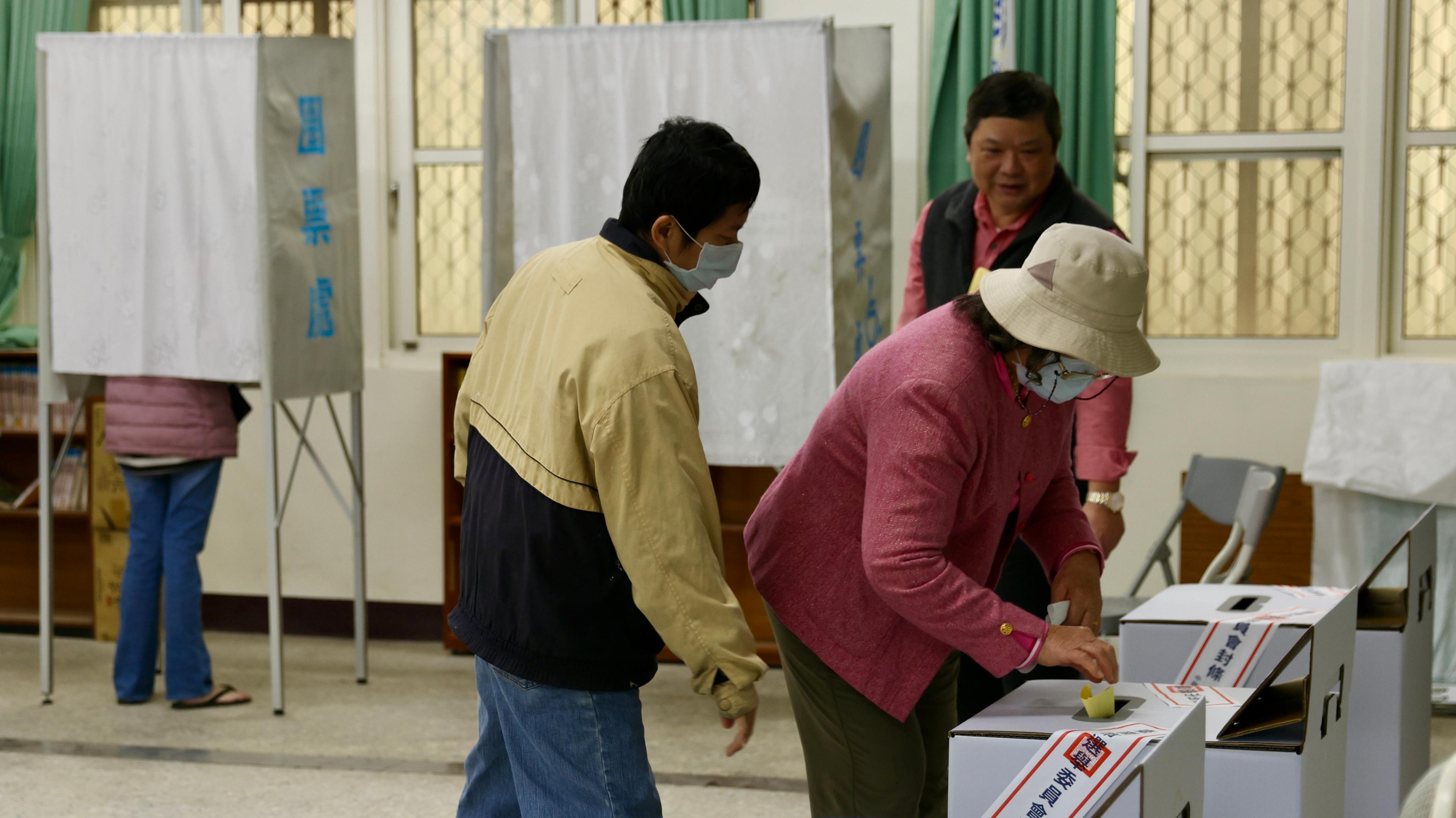 Menschen geben in einem Wahllokal in Taiwan ihre Stimmen ab.