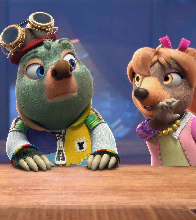 Vor blauem Hintergrund sitzen Dotty, Moley und Mona Lisa als Jury nebeneinander an einem Pult und betrachten mit kritischem Blick, was auf der Bühne präsentiert wird.