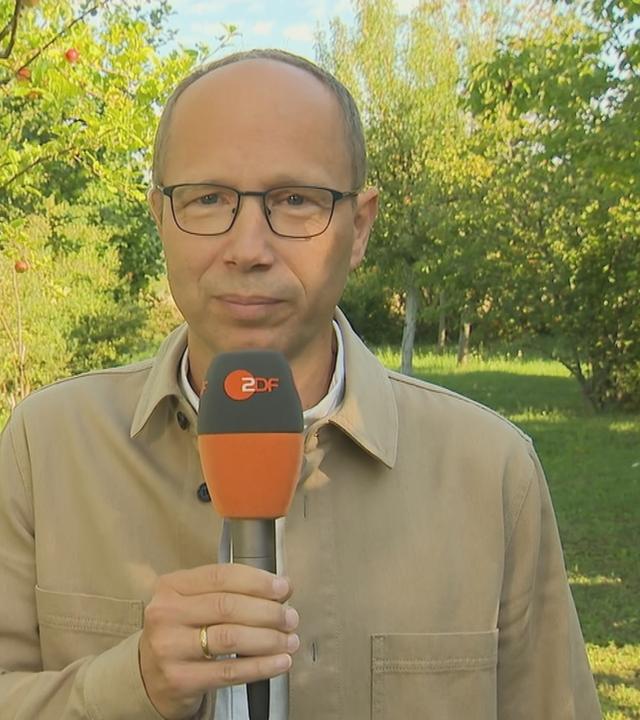 Mark Hugo frontal vor Apfelbäumen