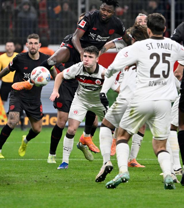 Leverkusens Edmond Tapsoba setzt sich gegen Arkadiusz Pyrka und Jackson Irvine durch und erzielt das Tor zum 3:0 per Kopf