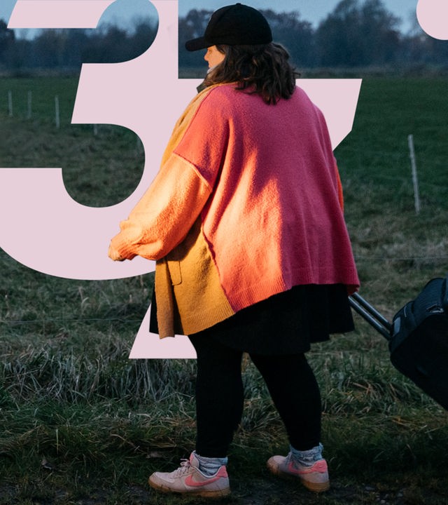 Miriam Peters steht neben ihrem Beratungsbus und reicht einer Frau die Hand.