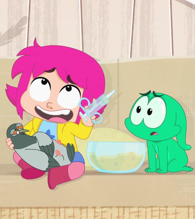 Rebecca hat eine Taube auf dem Schoß und eine Spritze mit Futter in der Hand. Ernest sitzt neben ihr auf dem Sofa.