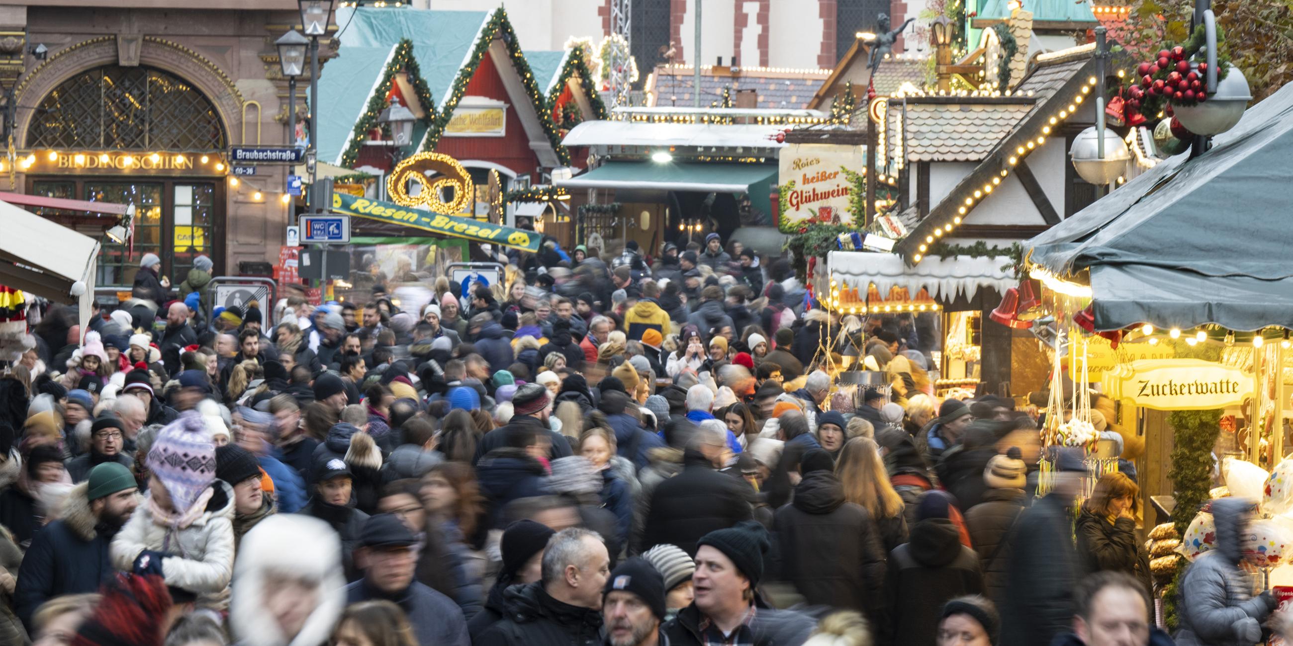 Tausende Besucher strömen zwischen den Verkaufs- und Imbissständen auf dem Weihnachtsmarkt in Frankfurt hindurch. 
