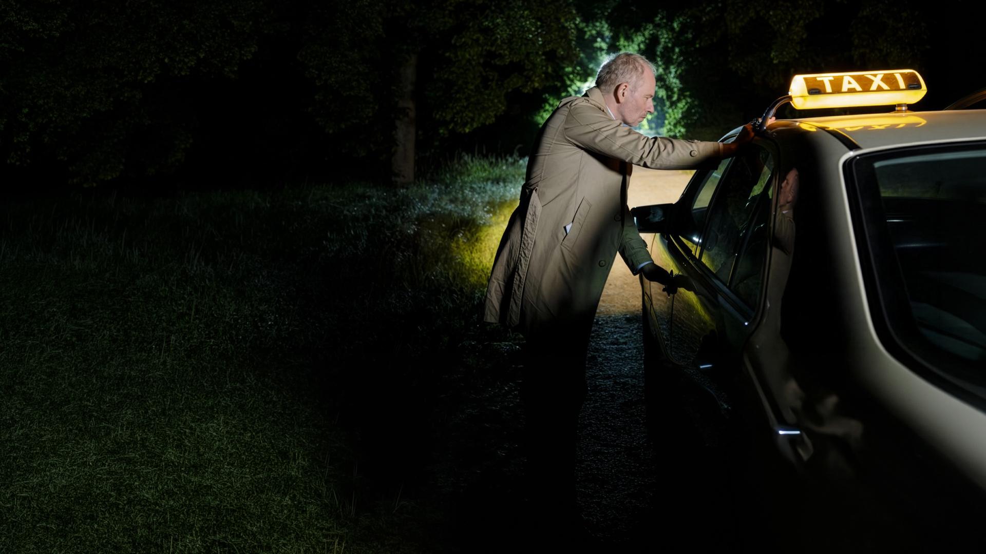 "SOKO Potsdam - Taxi nach Nirgendwo": Bernhard Henschel (Michael Lott) steht auf einem verlassenen Feldweg neben dem Taxi. Die Türen sind durch den Fahrer verschlossen, er kommt nicht mehr hinein. Das Taxi fährt davon.