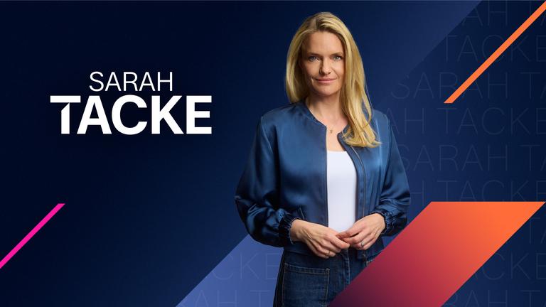 Sarah Tacke schaut selbstbewusst in die Kamera. Hinter ihr ist ein grafischer Hintergrund in blauen Farbklima mit orangenen und magentanen Akzenten zu sehen