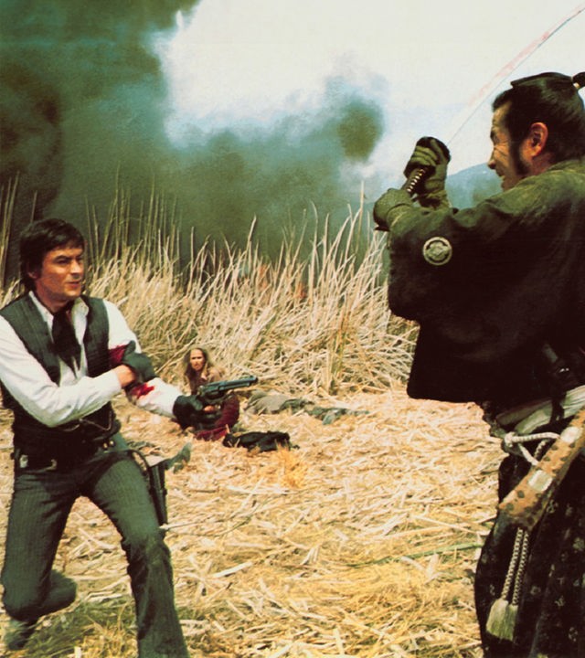 Gauche (Alain Delon) steht mit blutverschmiertem Arm und gezogener Pistole in einem Feld aus trockenem Gras, während Kuroda (Toshirô Mifune) ihm mit erhobenem Schwert gegenübersteht. Im Hintergrund sitzt Christina (Ursula Andress) geduckt zwischen den Gräsern, während dunkler Rauch aufsteigt.