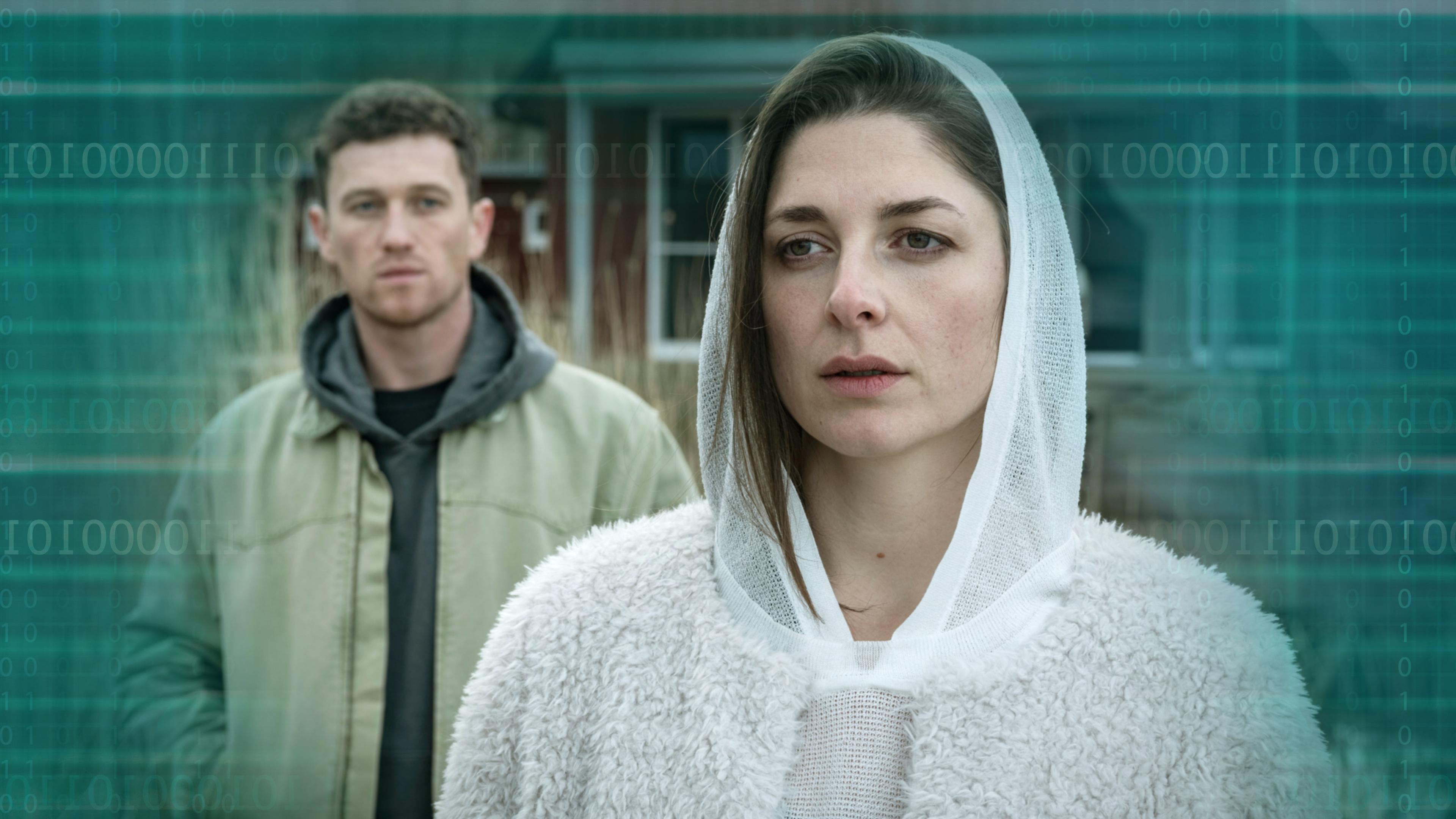 "Die Whistleblowerin": Galina Gromowa (Katharina Nesytowa) steht vor einem schwedischen Ferienhaus und schaut in die Ferne. Hinter ihr steht Tom Arndt (Artjom Gilz) und betrachtet sie. Das Binärsystem ist auf türkisem Hintergrund als Vignette hinterlegt 