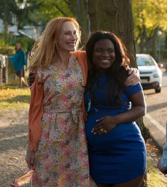 Gundula (Andrea Sawatzki) hält Candy (Ludie Diekumpovisa) auf der Straße im Arm, davor steht Rolfi (Oskar Bökelmann) und schaut die beiden an.