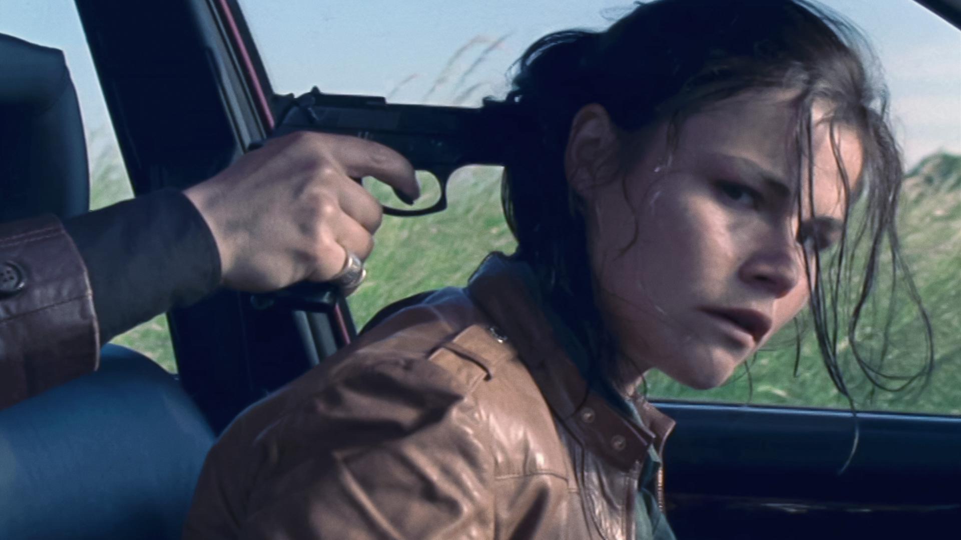 Kommissarin Nina Petersen (Katharina Wackernagel) sitzt auf dem Fahrersitzt eines Autos und bekommt eine Pistole an den Hinterkopf gedrückt. 