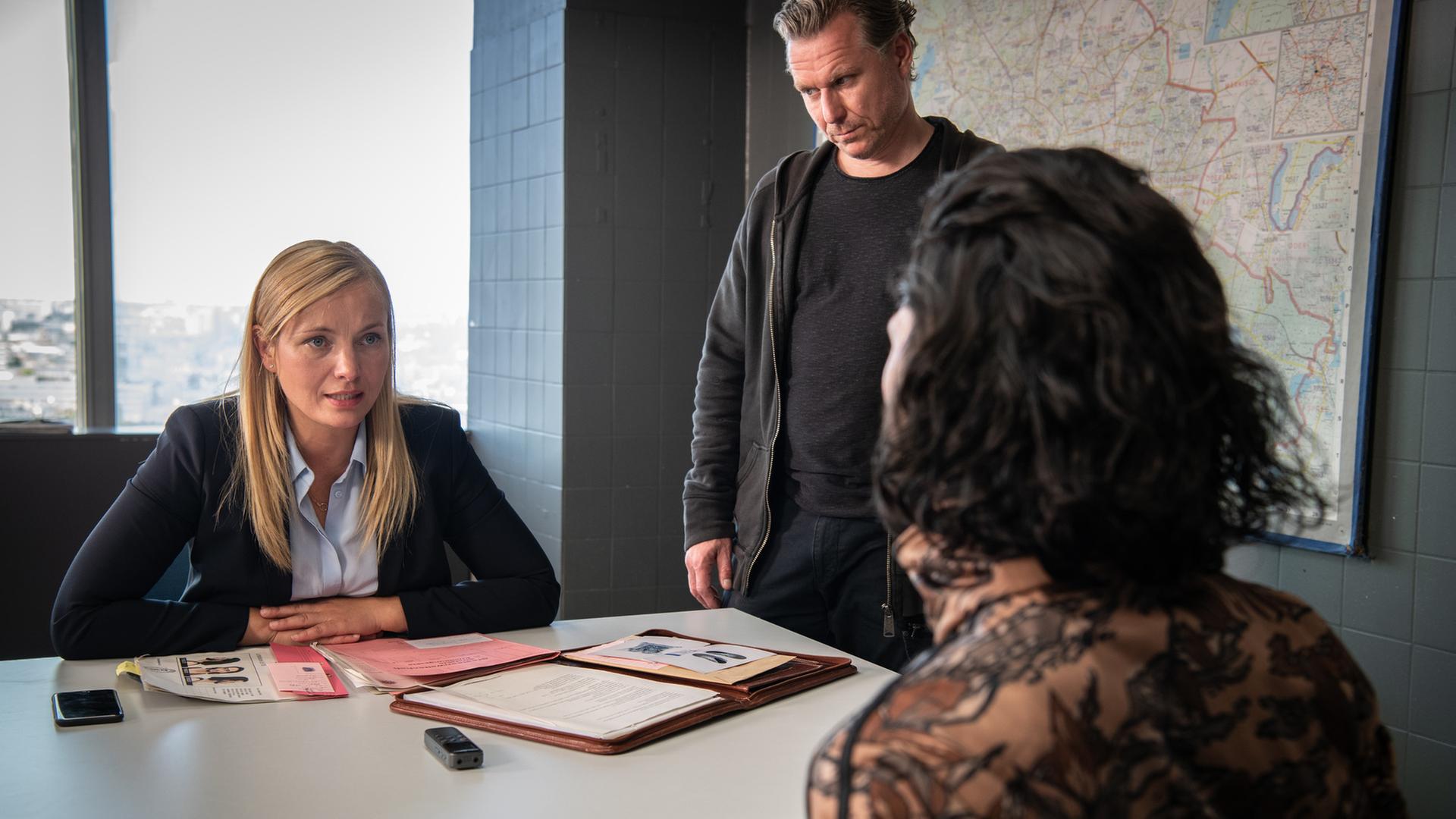 Staatsanwältin Judith Schrader (Nadja Uhl) und Kommissar Jochen Montag (Dirk Borchardt) befragen einen Mann, der nur von hinten zu sehen ist.