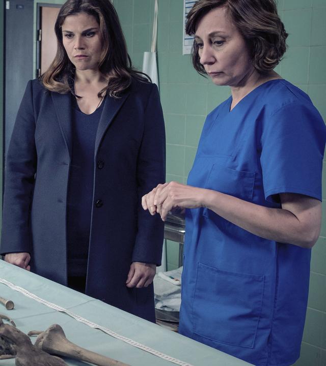 Kommissarin Nina Petersen (Katharina Wackernagel) und die Rechtsmedizinerin (Marina Weis) stehen an einem metallenen Tisch, auf dem ein menschliches Skelett liegt.