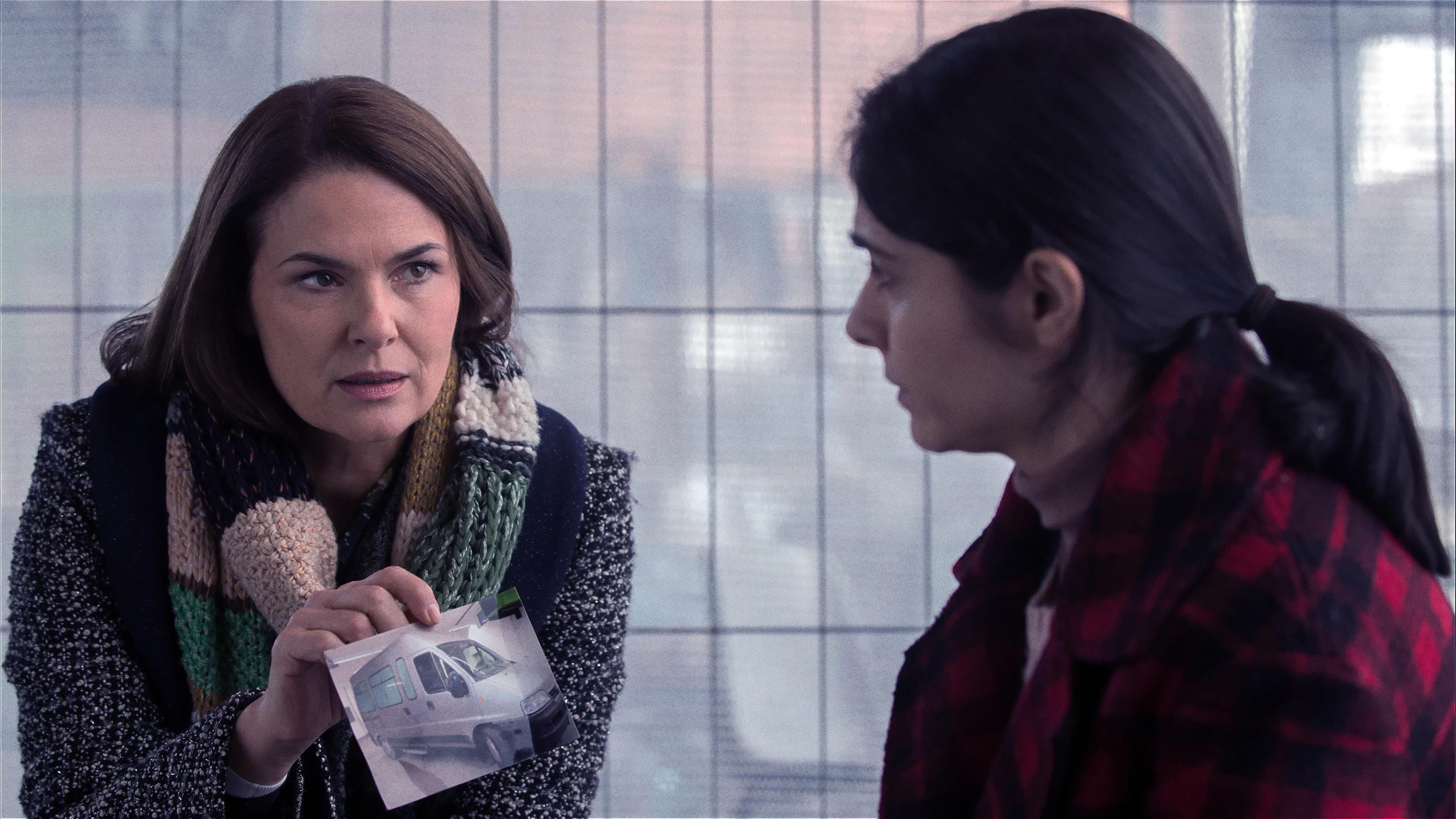 Lisa Brenner (Barbara Auer) zeigt Odile Bakri (Pegah Ferydoni) ein Foto mit einem Lieferwagen darauf.