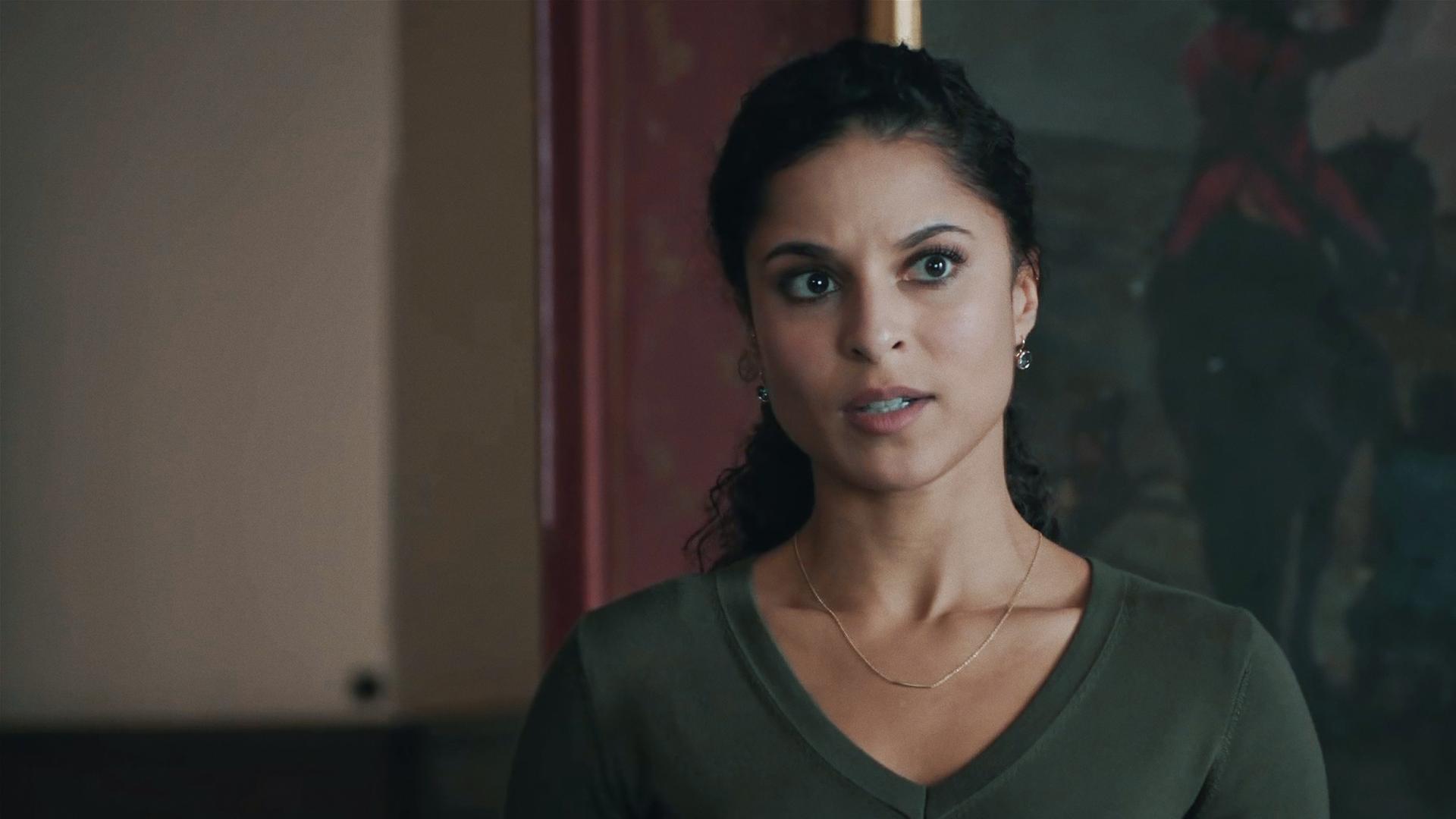 Tessa Tilker (Patricia Meeden) in einem Innenraum vor einem dunklen, kaumerkennbaren Ölgemälde. 