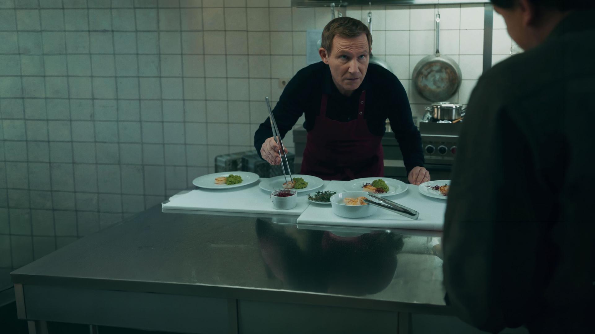 In der Hotelküche stehen Overbeck (Roland Jankowsky) und Kommissar Drechshage (Stefan Haschke) am Spülbecken.