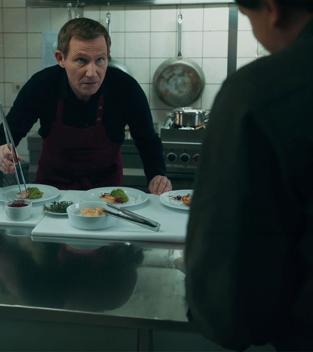 In der Hotelküche stehen Overbeck (Roland Jankowsky) und Kommissar Drechshage (Stefan Haschke) am Spülbecken.