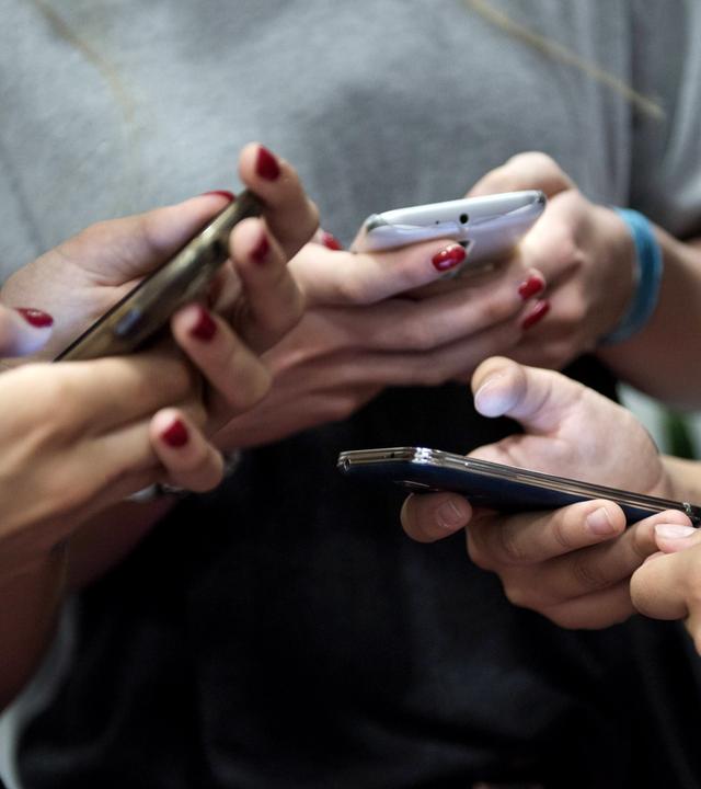 Eine Gruppe Teenager mit ihren Smartphones