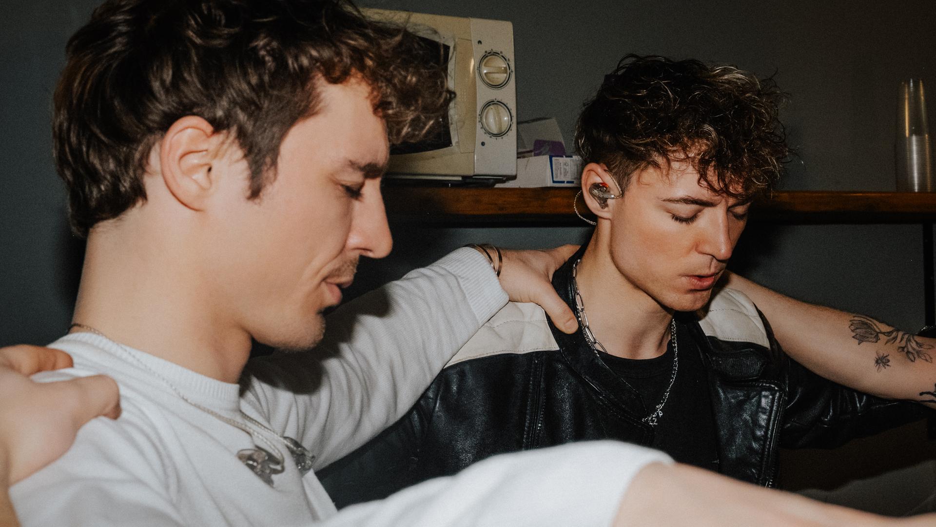 Heiko und Roman Lochmann stehen im Kreis mit einer dritten Person und haben ihre Hände auf die Schultern der anderen gelegt.