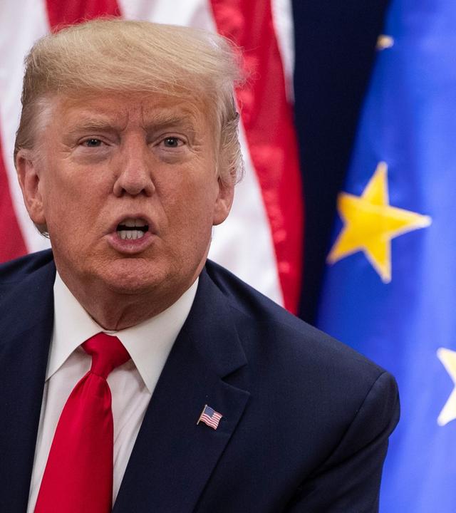 Donald Trump vor Flaggen der USA und der EU. Archivbild