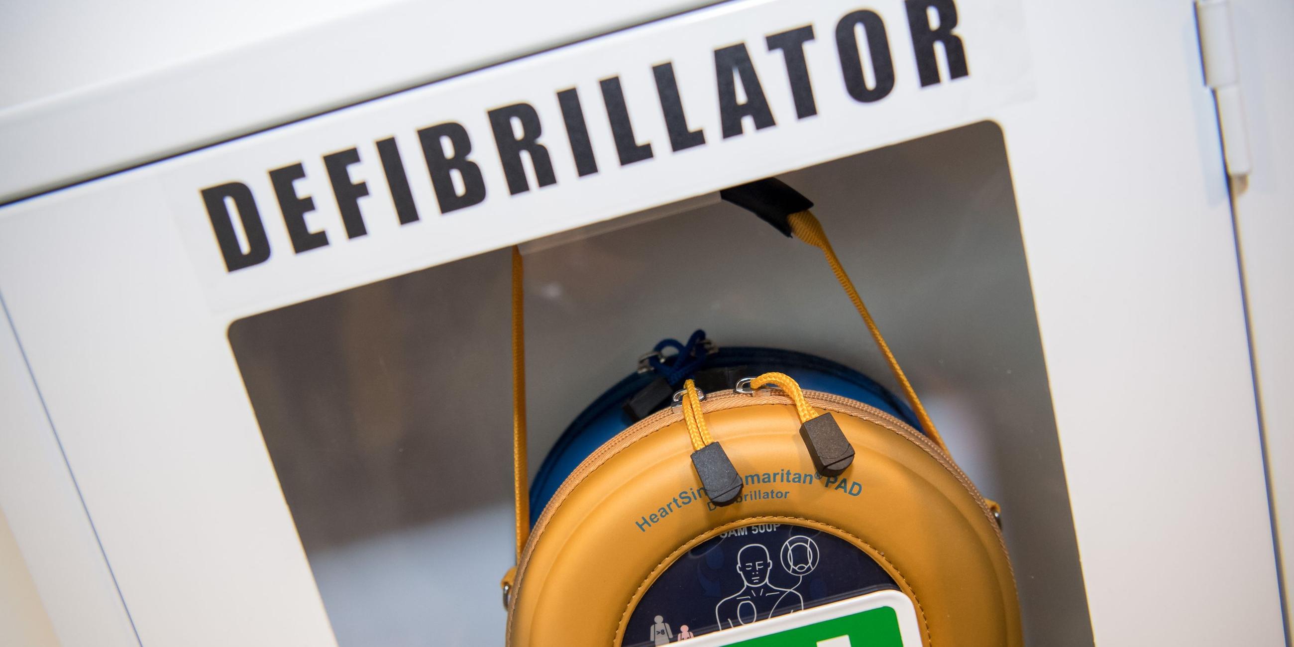 Ein Schränkchen mit einem Defibrillator. Symbolbild
