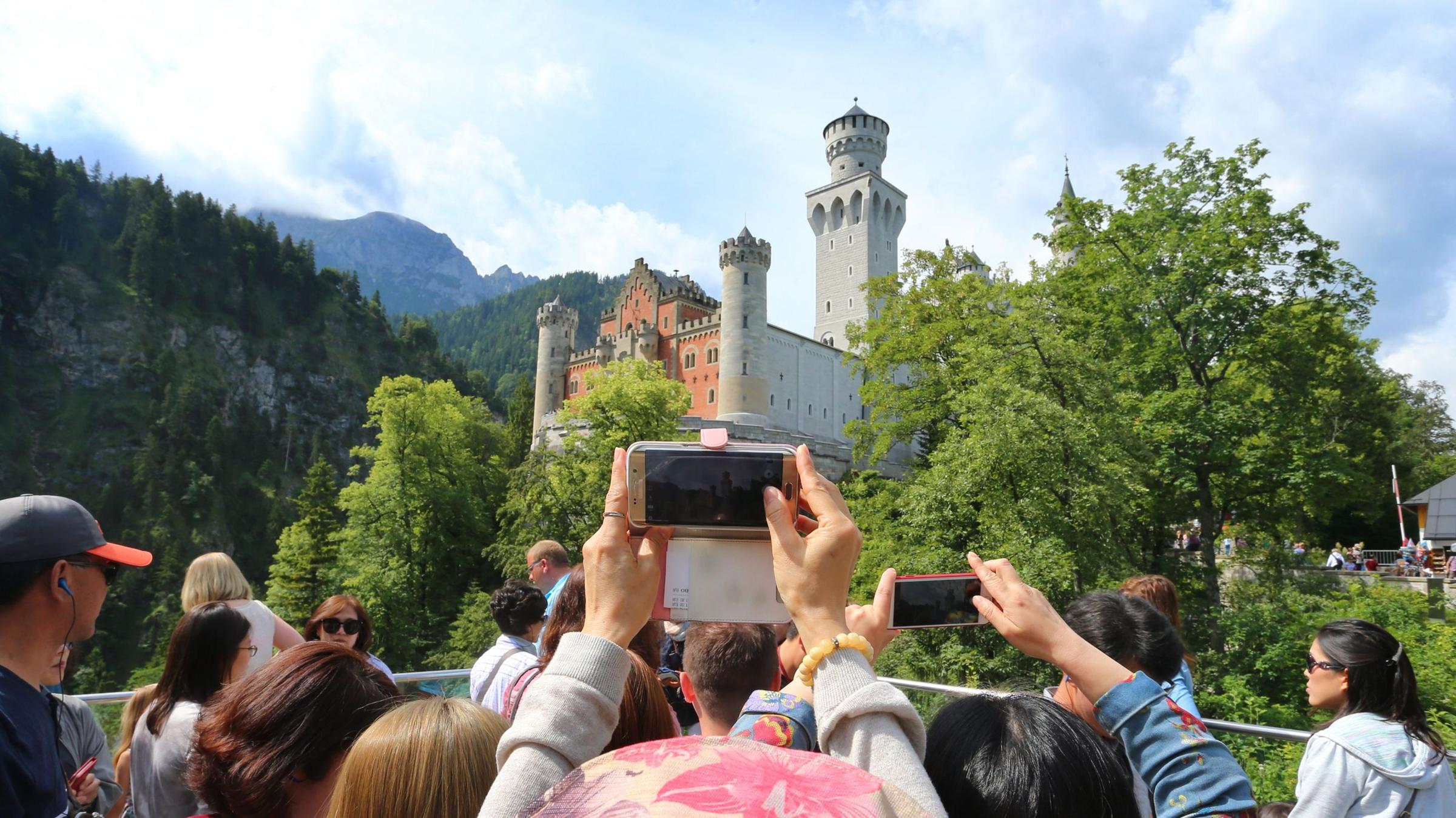 Touristen fotografieren das Schloss Neuschwanstein. Archivbild