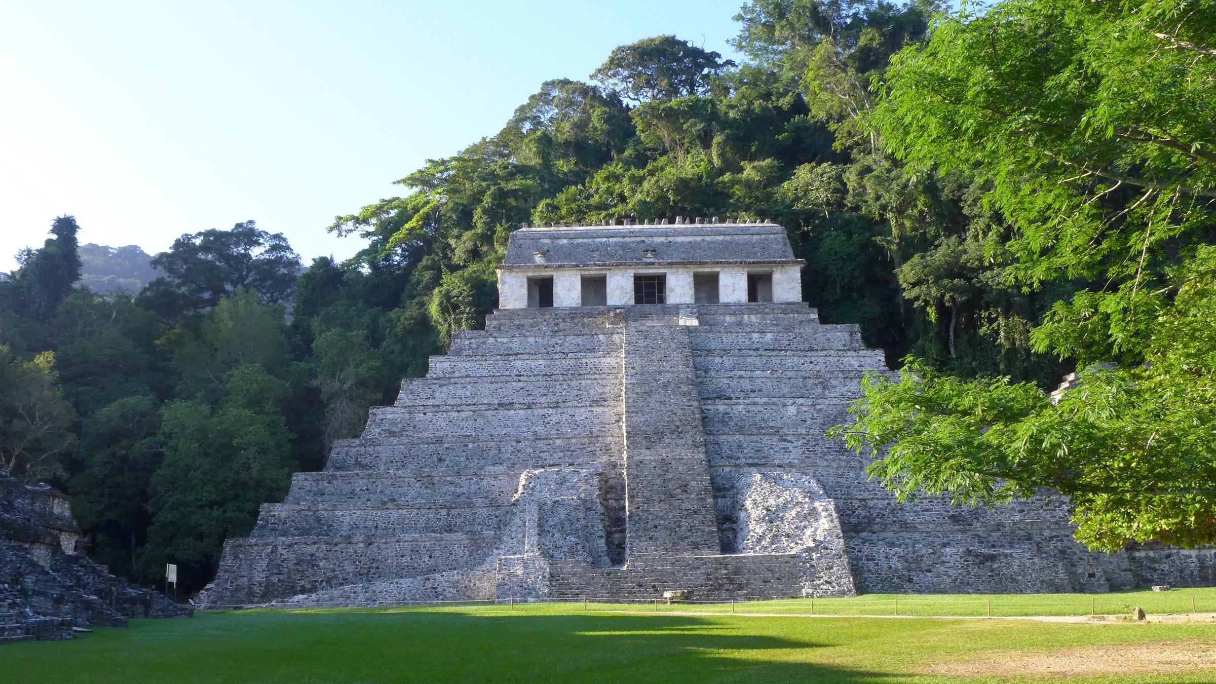 Mitten im Dschungel Mexikos steht der "Tempel der Inschriften". Vor ihm ist eine größere Wiesenfläche.