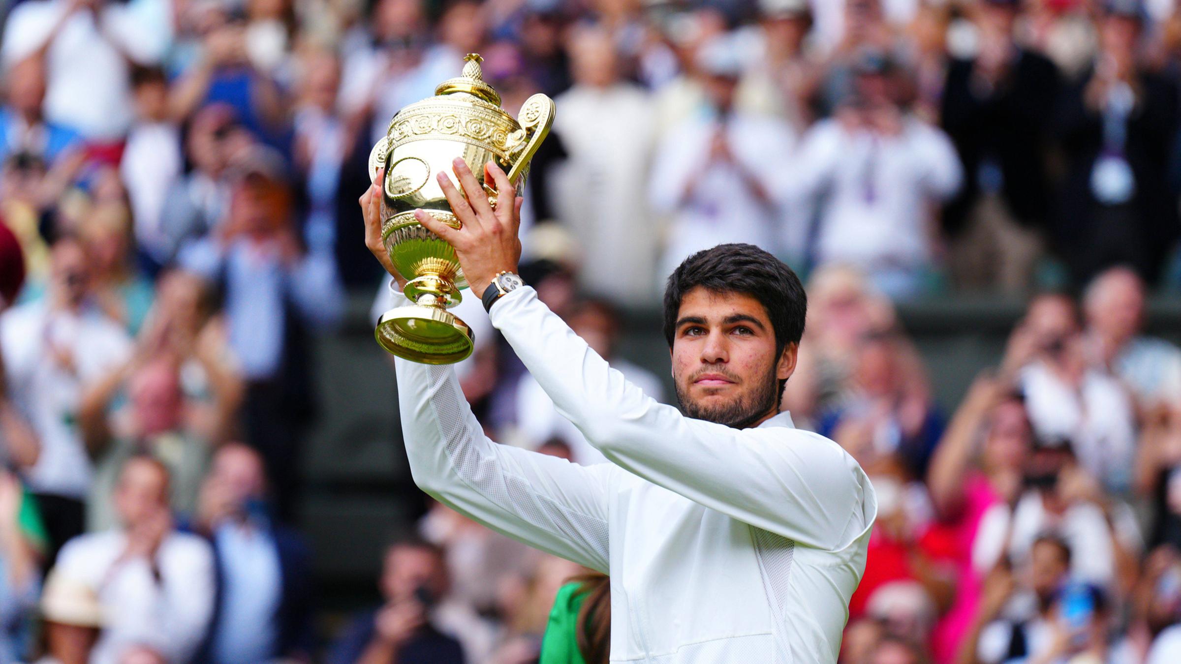Carlos Alcaraz hält den Pokal für den Sieg über Novak Djokovic bei den Wimbledon Championships.