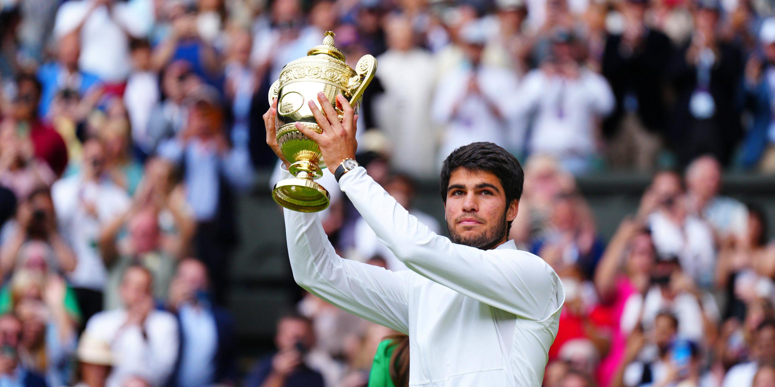 Carlos Alcaraz hält den Pokal für den Sieg über Novak Djokovic bei den Wimbledon Championships.