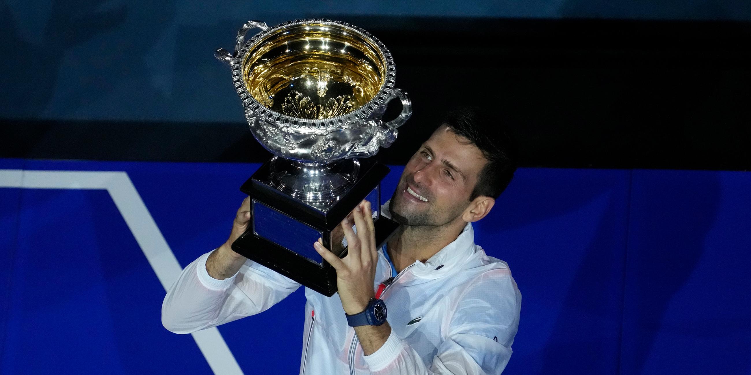 Novak Djokovic mit Pokal bei der Siegerehrung der Australian Open am 29.01.2023 in Melbourne.  